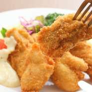 美味しさの秘訣はお店で作る生パン粉。非常に細かいパン粉のため、薄くカリッとした衣になります。11月～3月にかけて使用する牡蠣は水産のプロが選んだもの。現在は広島県産の大粒を仕入れています。