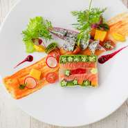 『鮮魚の燻製テリーヌ』は、沖縄の食材をふんだんに使用したフレンチらしい彩り豊かな前菜の一皿。ドラゴンフルーツなど沖縄でとれる南国フルーツや、地元農家から直送される野菜が料理に活かされています。