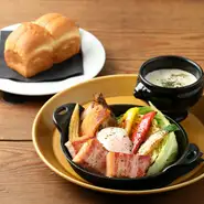 熱々の鉄板に季節の野菜と厚切りベーコンのグリル、仕上げに半熟卵をのせました。セットでクラムチャウダーが付きます。サラダにかけてもそのままスープとして飲んでもと、食べ方次第で味わいが変わるサラダです。