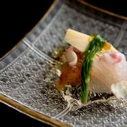 魚の熟成技を使った絶品の皿。特別な処理を施して数日ねかした魚は、旨みが増して脂の乗りも最高潮に。それを昆布じめにして味に奥行きをもたせ、自家製の2種類のジュレをトッピング。旬の野菜8～9種を添えて。