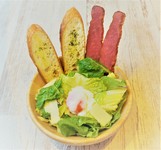 ブラックペッパーのアクセントに温玉のまろやかさを加えた定番のシーザーサラダ。