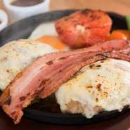 お店で一番ボリュームのある、トッピングが充実したハンバーグです。ハンバーグ、7mmの厚切りベーコン、焼きトマトが一皿に。表面を焼いてからオーブンに入れたトマトは、柔らかくて甘いのが特徴です。