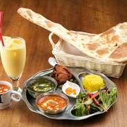 女性にも大人気のボリューム満点なセット！「日替りカレー＋チキンカレー/ダルカレー/キーマカレー/チキンサグワラから1つ・ナンandターメリックライス・タンドリーチキン」がついた、ランチ限定メニューです。