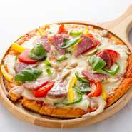 ピザ生地は薄めで、パリッとした食感のミラノ風。その上には、たまねぎ、トマト、サラミ、ピーマン、パプリカなどの具材がたっぷり載っています。ピザ用の窯で、しっかり焼き上げた本格的なピザです。