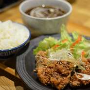 定食新登場！醤油ベースで、蕎麦屋の秘伝のかえしを使用し、仕上げにネギ香味タレと白ネギをトッピング油淋鶏風に。