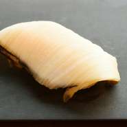 鮑は熟成せずに提供。素材のもつ本来の香りを際立たせるため、江戸前の仕事を施し、薄く、広く切って握ります。