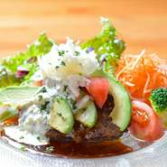 オーブンでじっくりと焼き上げた合挽肉のハンバーグに、相性抜群なトマトとアボカド、自家製ソースをコラボ。ソースのほのかな酸味により、さっぱりといただける一皿です。チーズの風味がさりげないアクセントに！