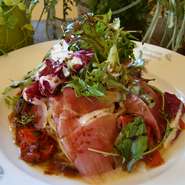 切りたてのパルマ産生ハムをたっぷり使った贅沢パスタ。フレッシュのベビーリーフと自家製バルサミコソースと一緒に召し上がってください。