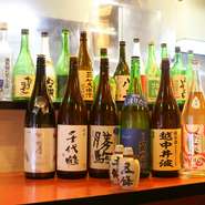 富山県内各地の酒造から厳選された地酒を種類豊富に取り揃えています。どれも富山の名産物を使った料理との相性が抜群。『〈本江酒造〉蜃気楼の見える街　吟醸』『〈吉乃友酒造〉よしのとも六割精白　純米酒』など。