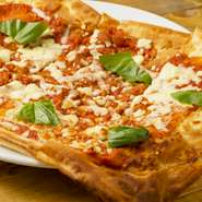 バジルとトマトソースの定番ピザ。ただし、ビザ生地がパイのようにサクッとしているので、よそにない新しい食感を味わえます。取り分けしやすい四角い形が特徴的。