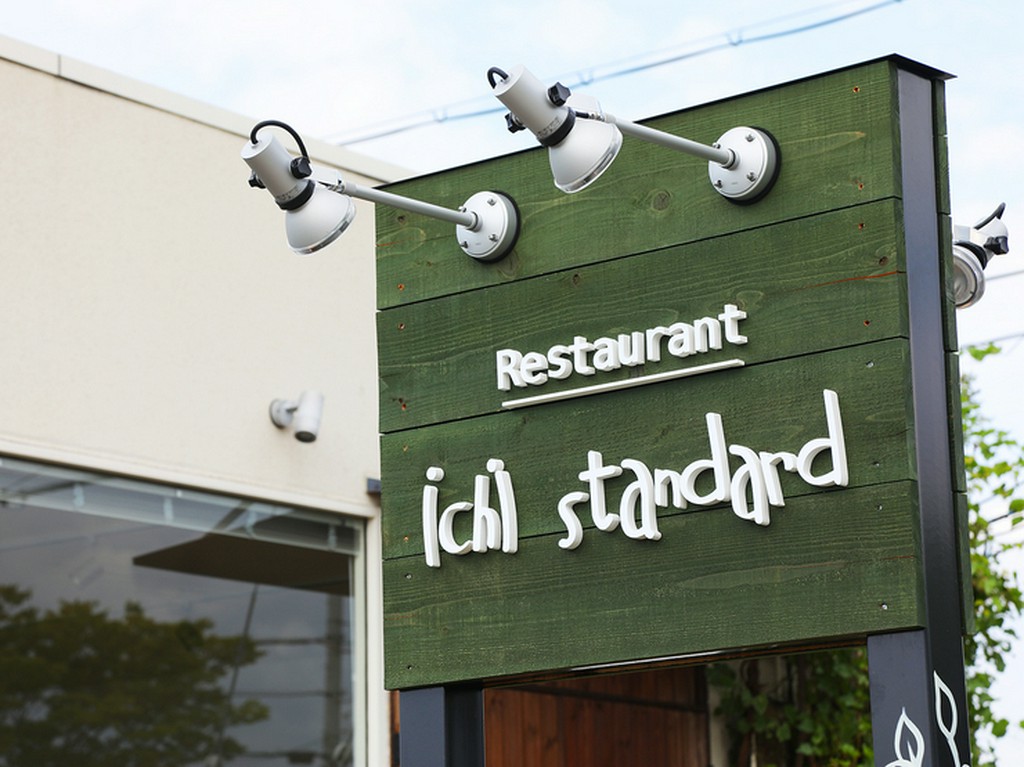 深い緑色の木の看板が目印