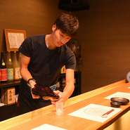 「お一人様は特別待遇です（笑）」と笑顔で語る店長の渡辺氏。板造りの掘りごたつ式カウンターで、店長と会話をしたり隠し酒を愉しんだりできます。ゲストのことを一番に考えた、心地良い接客の虜になりそうです。