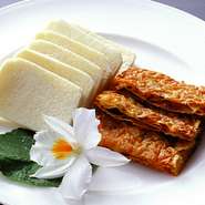 食感の良いパリッと仕上がった湯葉の間に、香り高い燻製肉と香味野菜が挟み込まれています。甘味噌をつけた、ふわふわの蒸しパンに包んでいただく逸品。心地よい食感と共に広がる、素材の旨みがたまりません。