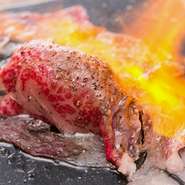 『馬肉寿司』は、当店の名物！！熊本県産高級な馬肉をバーナーで豪快に炙る迫力満点の一品です。鼻から抜ける香り、肉厚だけでトロけるような舌触り。食べごたえも抜群！馬肉本来の旨味をお愉しみ下さい！