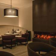 スポットライトのように照らされたテーブルとフェイク暖炉の火の揺らぎがロマンティックな空間を演出。包み込まれるような広いソファー席は二人の隔たりを無くし、グッと二人の距離を近づけます。