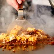 鉄板中華料理店での修業経験もある店主が、鉄板の上でつくる特製麻婆豆腐。にんにく不使用、ラー油も控えめながら味はしっかり。お好みで追いラー油を。他店ではない麻婆豆腐のおこげが味わえます！