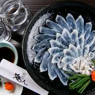 新鮮なとらふぐならではのプリプリの身を楽しめる刺身。直送で仕入れるものならではの透明感と深い味わいがクセになります。とらふぐはほかにから揚げ、寿司、雑炊などがあり、好みの食べ方で堪能することも可能。