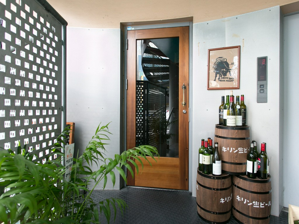 玄関脇に積まれたビール樽とワインボトルが目印