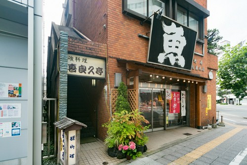 鮮魚店の左の階段を昇ると店の入り口へ