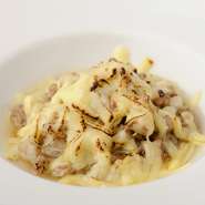 夜のコース料理の一品。蕎麦米（蕎麦の実を茹でて乾燥させ、殻を取ったもの）を100％使っているので、香ばしさとモチモチ食感が最高。河内鴨と香味野菜からとったブイヨンで仕上げる、滋味深い味わいも自慢。