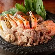 看板メニュー『石鍋基本コース』のお鍋は、秘伝のごま油にたっぷりのお肉を入れ、厳選した食材がぎっしり詰まった珠玉の逸品。丁寧にひかれた出汁が、素材の旨みを引き立てる【石鍋のぐち】オリジナルの鍋料理です。