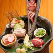 馬刺し・和牛炙りタタキ・土鶏タタキ刺しを盛った一皿。食材ごとに炙り方を変えて旨味を引き出した肉に九州ジョーキュウ醤油・丸島醤油・柚子ぽん酢をつけていただきます。薬味と一緒に食べるのが特にオススメ。