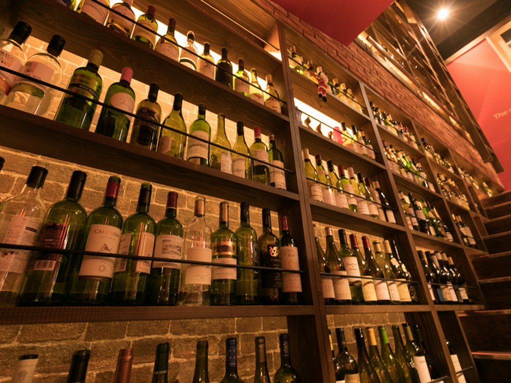 床から天井まで、吹き抜けの階段をワインボトルで埋めつくす