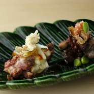 胸肉の塩焼き（左）は、焼いてからすっぽんの出汁で炊いたごぼうとネギを添えて。上のすっぽんの皮煎餅がアクセントに。もも肉と肝のたれ焼き（右）は、赤ワインと山椒の実が加えられたタレがコクを与えます。