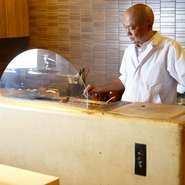 カウンターに座ると大きな焼き台が目を引きます。炭台は、四日市の陶芸家、内田鋼一さんによる特注品。食材が焼かれる姿を見ながら、耳、目、鼻で出来上がりまでを楽しんでください。