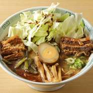 野菜をしっかり食べてほしいという創業者の想いから、生キャベツがどっさり盛られた『太肉麺』。柔らかく煮られた角煮とともにいただきます。こちらは東京で開発されたラーメンで、誕生から50年が経ちます。	