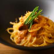 濃厚なソースとよく合う平打ちパスタ「タリオリーニ」、濃厚ウニにさっぱりとした黄色いトマトで作ったソースを絡めて。上から削ったオレンジ色のリゴレットチーズがアクセントの一皿。
