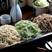 蕎麦の実の芯の部分から採った白い「更科蕎麦」蕎麦の実の甘皮ごと挽いた黒い「田舎蕎麦」季節で変わる色味もきれいな「香り蕎麦」の3種を楽しめる一品。異なる香り・コシ・喉ごしを一度で味わう人気メニューです。