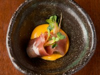 黄身酢の上に浮かぶ生ハム。出汁でのばした黄身に酢を加えた黄身酢は、口に入れると上品な酸味が広がります。生ハムの塩味だけでは少し物足りなく、ミョウガを加えることで大人が好む一品となっています。