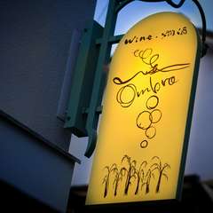 夕暮れ時に浮かび上がる、葡萄がデザインされた【Ombra】の看板