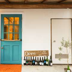 ブルーのドアと行儀よく並んだワインボトルがお店の目印