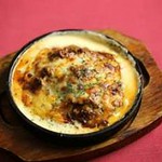 グラナ・パダーノをお皿代わりに大胆に使用したリゾット。トリュフをはじめとしたきのこの豊かな香りと旨味がチーズに合わさって贅沢な味わい。