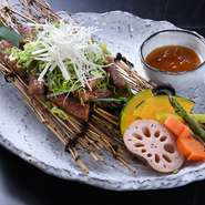 香ばしく焼き上げた黒毛和牛のリブロースの上に、白髪ネギや青ネギをたっぷりと散らした一品です。