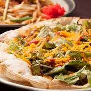 食べごたえ抜群のオリジナルピザ。タコミートをピザ生地にたっぷり敷き詰め、フレッシュなレタスやベビーリーフとチーズをトッピング。満足感のある、沖縄らしい人気の一品です。