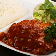 厚さ2センチの厚切りロースポークソテーに、ケチャップ味のソースがたっぷりかかっています。ソースは赤ワインの隠し味が効いた大人の味わい。素揚げのポテトとの相性もぴったりです。