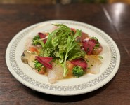 今日のお刺身にあるようなネタを中心に多種の魚介を自家製のカルパッチョソースで。旬の野菜も楽しめて近年は特に女性に人気の一皿です。