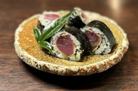 4貫入り。比較的近年に高知の居酒屋で誕生した高知名物。カツオたたきにネギ、大葉、ニンニクなど薬味を並べ太巻き寿司にします。