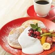 定番のリコッタパンケーキにたっぷりのフルーツとクリームを添えた、おすすめの一皿