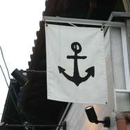 町屋の看板に掲げたイカリの旗が目印
