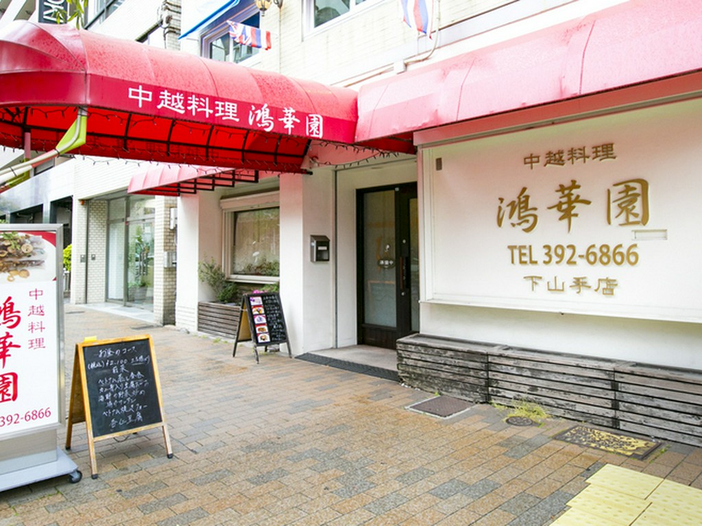 白い壁に赤いシェードが映える、モダンな外観