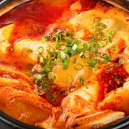 鶏ガラと牛骨を5～6時間かけて、コトコトと煮込んだスープを使用した特製『スンドゥブチゲ』。主役の豆腐のおいしさがひきたつ、辛い中にもコクのある味わいを楽しめる鍋料理です。