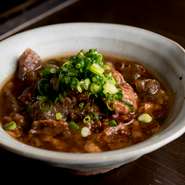 和牛の牛すじを、コトコト煮込むこと8時間。やわらかく煮込まれた牛すじとこんにゃくのプルプル食感がたまらない『牛すじ煮こみ』。味付けは、味噌2種類と醤油ベース。隠し味の赤みそのコクがしっかり効いています。