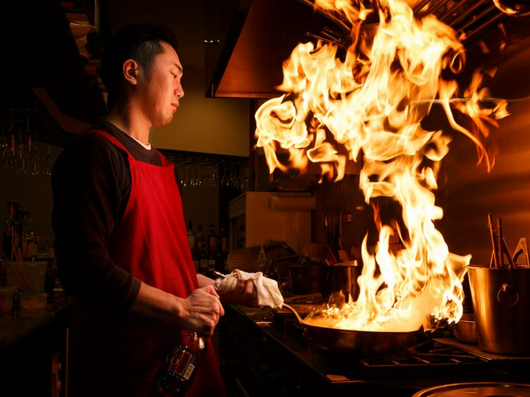 シェフが腕を振るう姿が見える、カウンター奥のキッチン