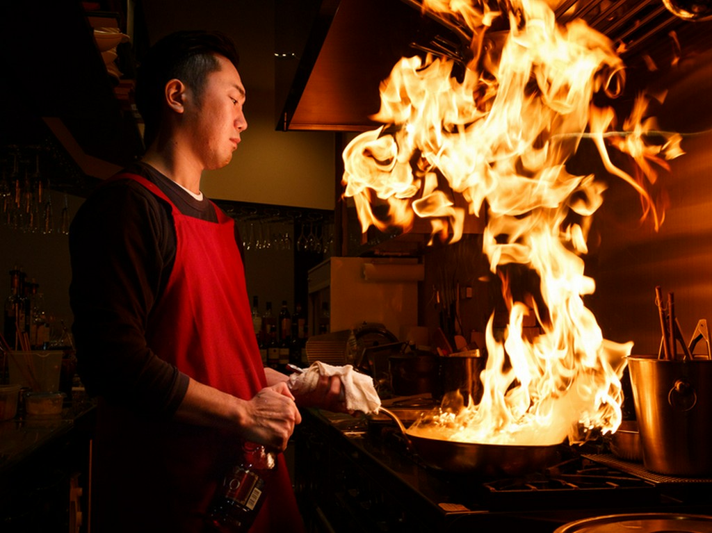 シェフが腕を振るう姿が見える、カウンター奥のキッチン