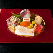 中央奥にそっと置かれた「鯖寿司」は、シャリのまろやかな酸味と脂ののった肉厚の鯖とのバランスが絶妙な一品。器の朱色の艶やかさと料理の華やかさに心躍らせるはず。メイン料理へのプレリュードとして、十分至極。