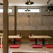 和食を提供しつつも、オシャレな空間で過ごしてもらいたいと、店内はオープンカフェのようなつくりに。木の風合いを活かした棚やテーブルは手造りというこだわりようで、ポイントカラーの赤が映えます。				